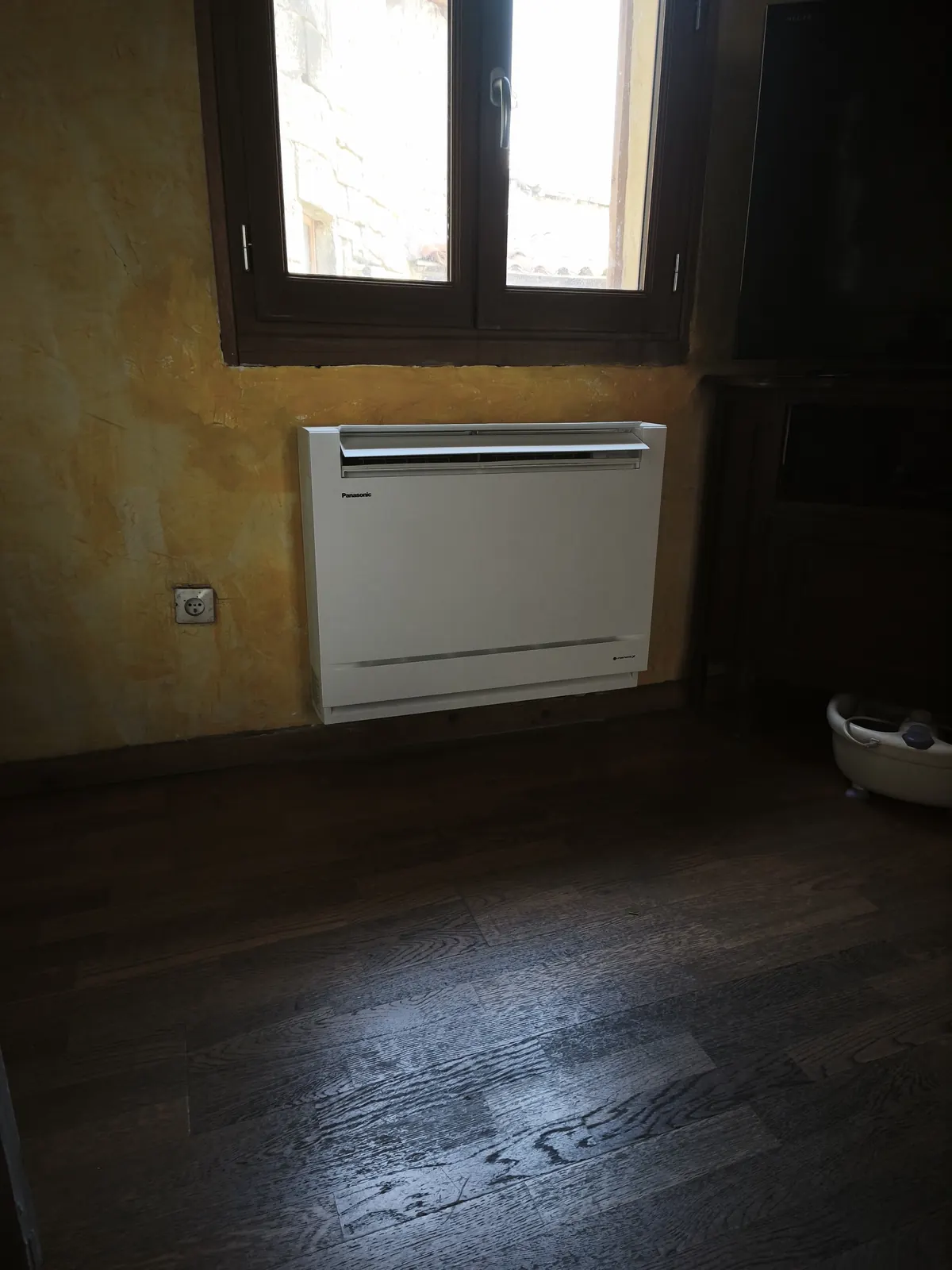 Console de climatisation Panasonic installée sous une fenêtre